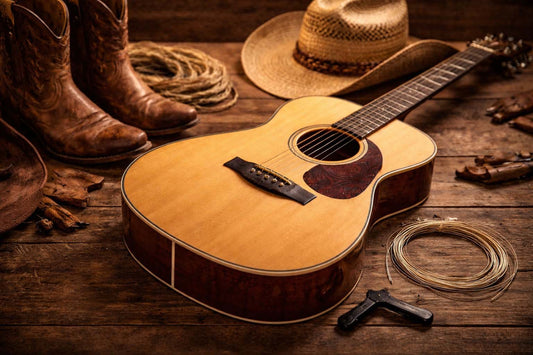 Acoustic guitar on a rustic wooden surface with cowboy boots and hat, representing country music style