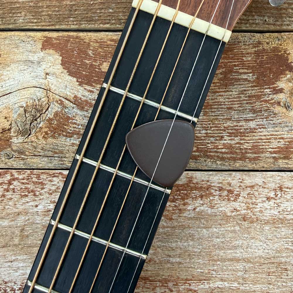 dark brown triangle guitar pick for bluegrass on acoustic guitar